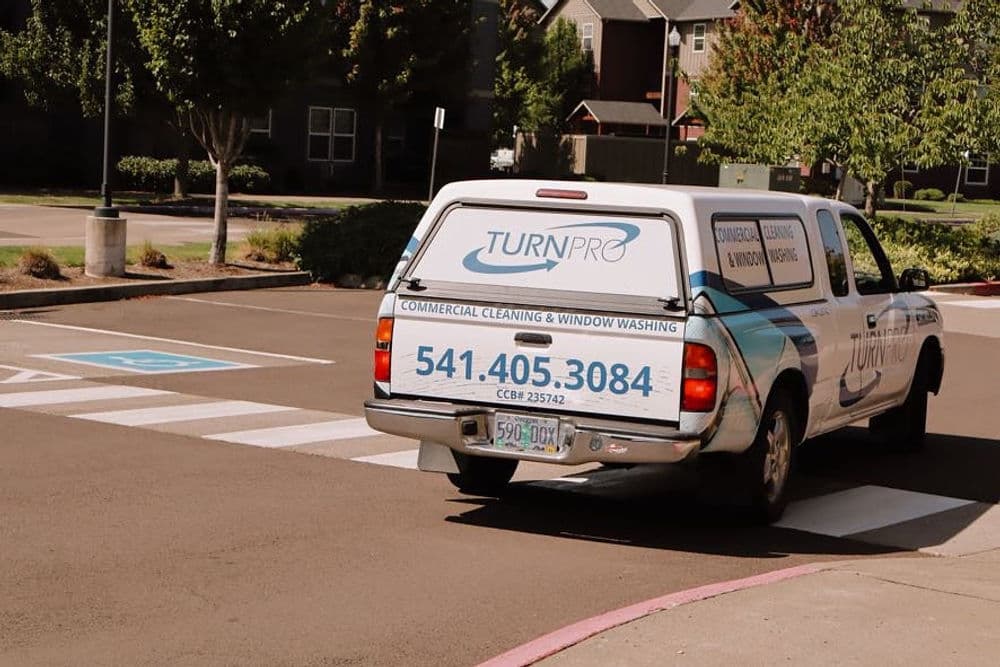 TurnPro commercial cleaning and window washing truck on a city street. Contact: 541-405-3084.