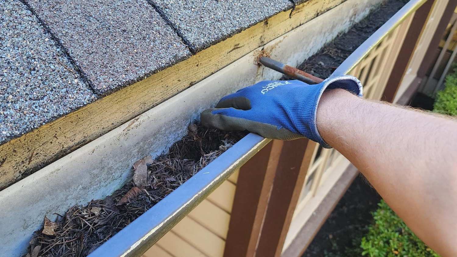 a image of a guy cleaning a gutter